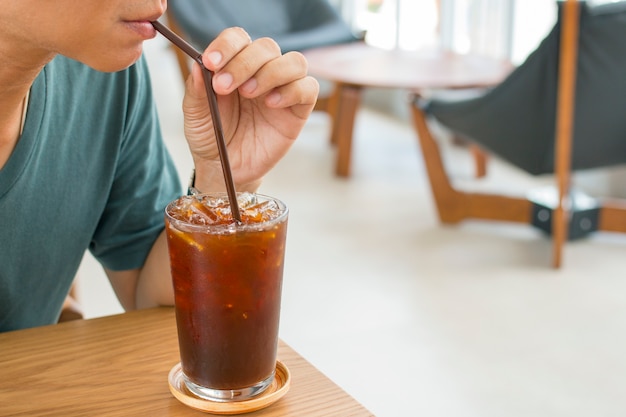 Mann, der ein Glas Eiskaffee trinkt