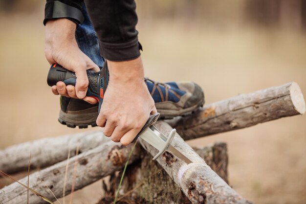 Mann, der ein Holz mit einer elektrischen Handsäge schneidet