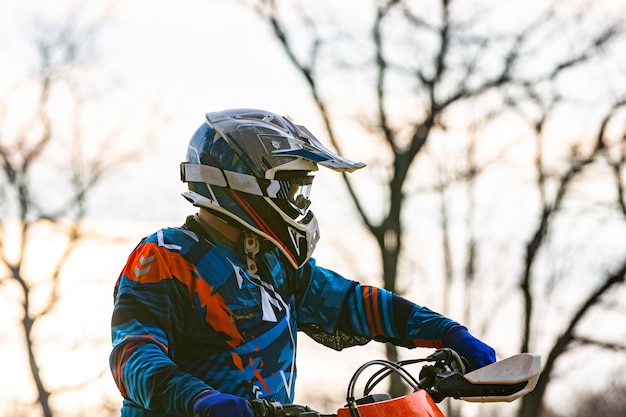 Mann, der ein motocross in einem schutzanzug reitet