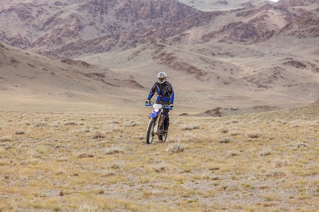 Mann, der ein Motorrad in den Steppen der Mongolei, auf den Hügeln der Mongolei reitet