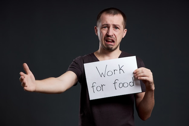 Foto mann, der ein zeichen mit den wörtern arbeit für essen hält