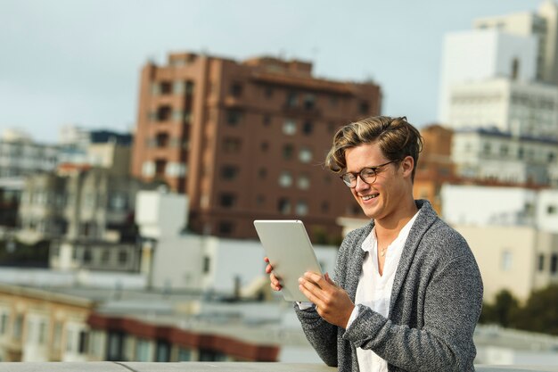 Mann, der eine digitale Tablette auf einer Dachspitze in San Francisco verwendet