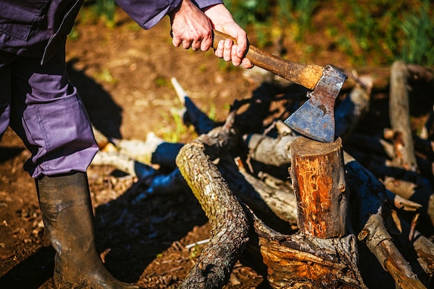 Mann, der eine industrielle Axt hält und Holz schneidet