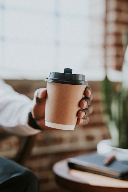 Mann, der eine Kaffeetasse zum Mitnehmen hält