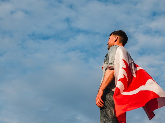 Mann, der eine kanadische Flagge hält. Nationalfeiertag