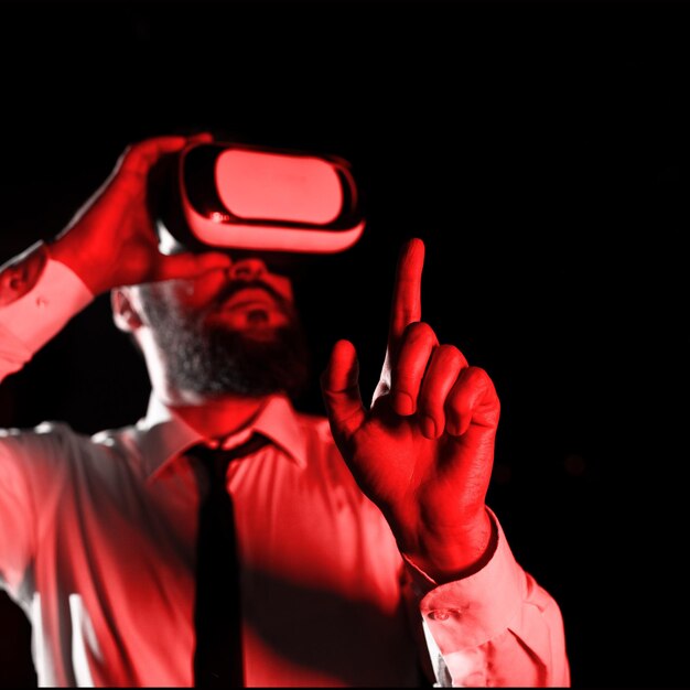 Mann, der eine Vr-Brille trägt und mit einem Finger auf wichtige Nachrichten zeigt Geschäftsmann, der eine Virtual-Reality-Brille hat und wichtige Informationen zeigt