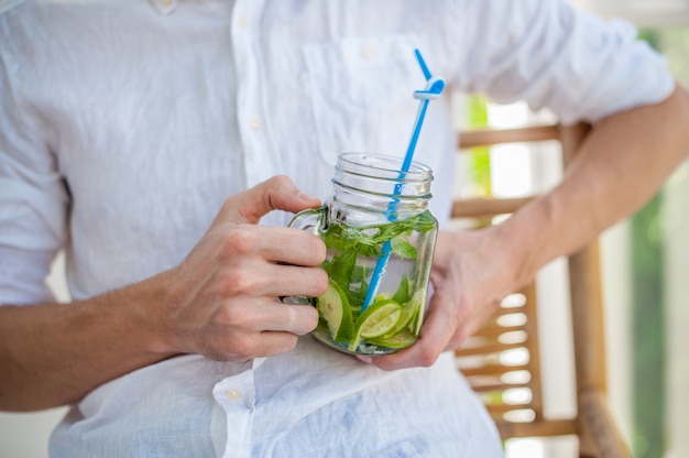 Mann, der einen Mojito auf der Terrasse trinkt.