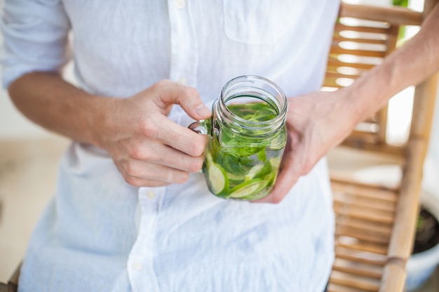 Mann, der einen Mojito auf der Terrasse trinkt.