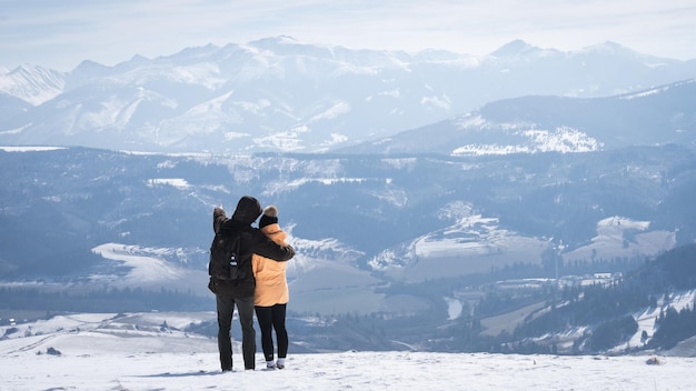 Mann, der einer Frau slowakei europa schöne alpine Winterlandschaft zeigt