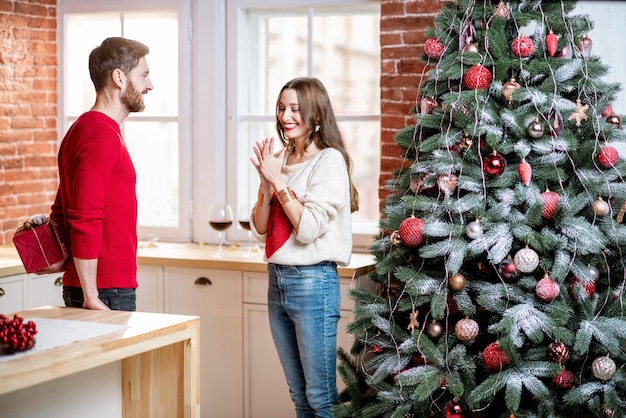 Mann, der einer Frau zu Hause ein Neujahrsgeschenk gibt