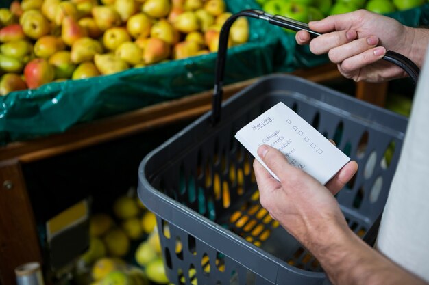 Foto mann, der einkaufskorb und checkliste hält