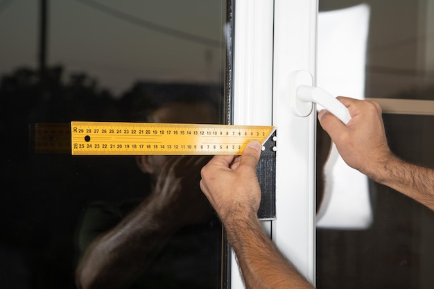 Mann, der Fenster misst. Neues Fenster im Haus installieren