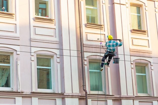 Mann, der Fenster und Wand auf Altstadtgebäude reinigt