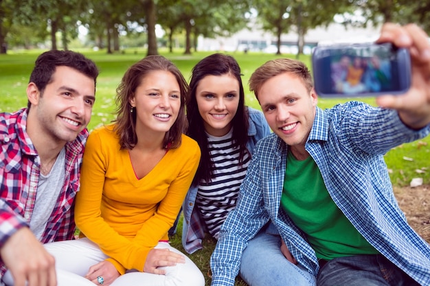 Mann, der Foto mit Collegefreunden im Park macht