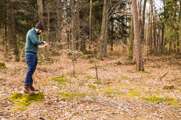 Mann, der Foto mit Smartphone im Wald macht