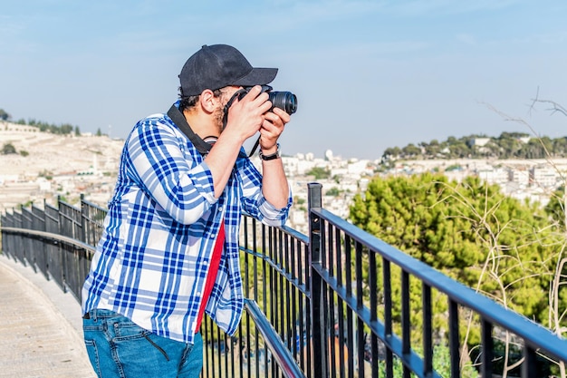 Mann, der Fotos mit einer DSLR-Kamera macht, die auf einer Brücke steht