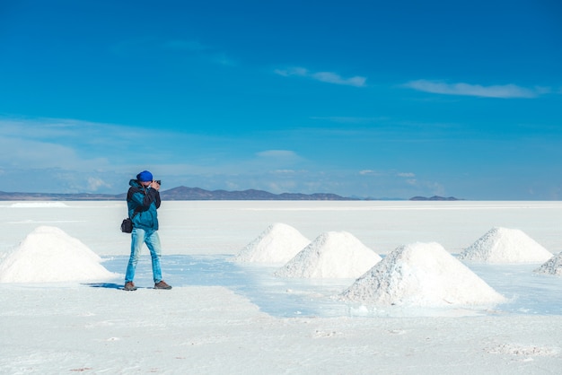 Mann, der Fotos von Salzbänken in Salar de Uyuni macht