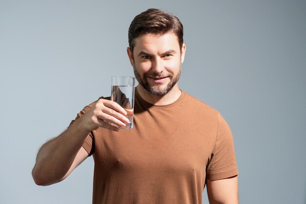 Mann, der frisches Wasser trinkt, männliches Modell hält Glas klares Wasser, gesunder Lebensstil, Gesundheitsfürsorge, Mineral