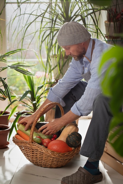 Mann, der Gemüse in seinem Indoor-Garten anbaut