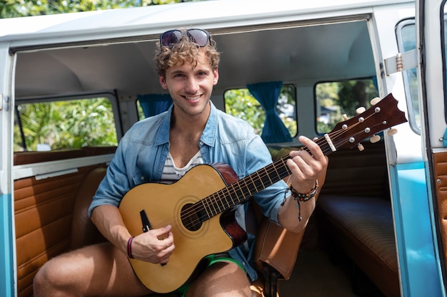 Mann, der Gitarre im Wohnmobil spielt