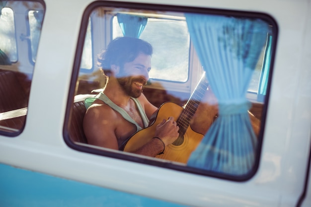 Mann, der Gitarre im Wohnmobil spielt