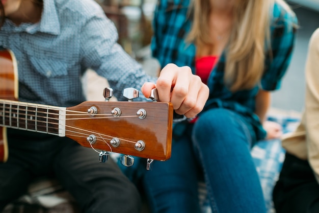 Foto mann, der gitarre stimmt. griffbrett-nahaufnahme. hobby musik freizeit. künstlerberuf