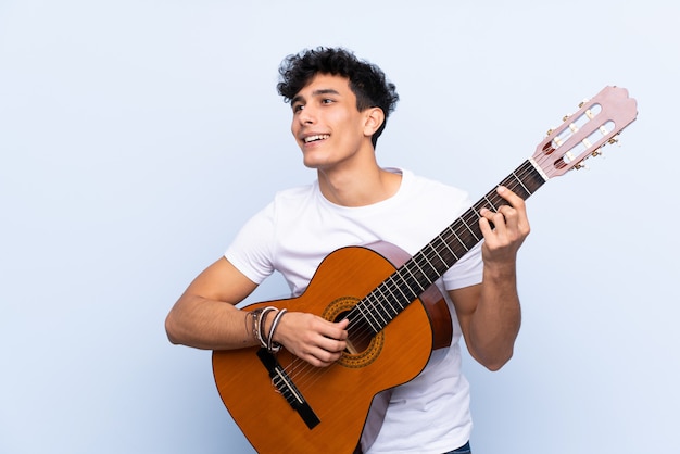 Mann, der Gitarre über lokalisierter Wand spielt