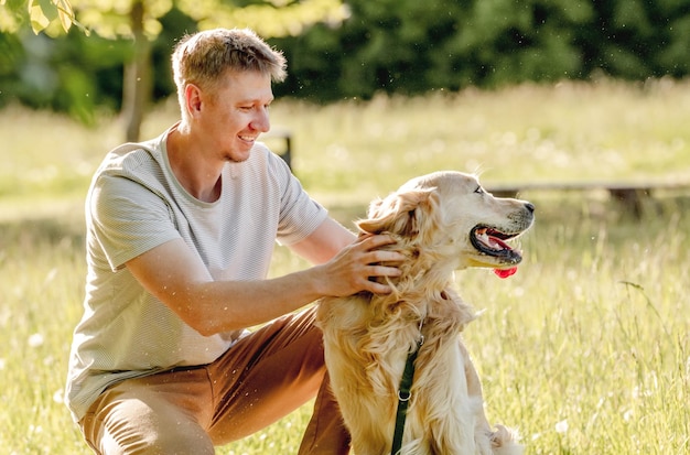 Mann, der Golden Retriever geht