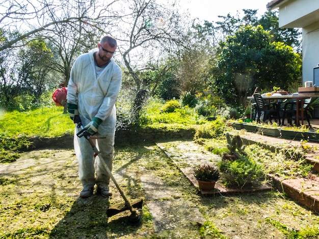 Mann, der Gras im Garten schneidet