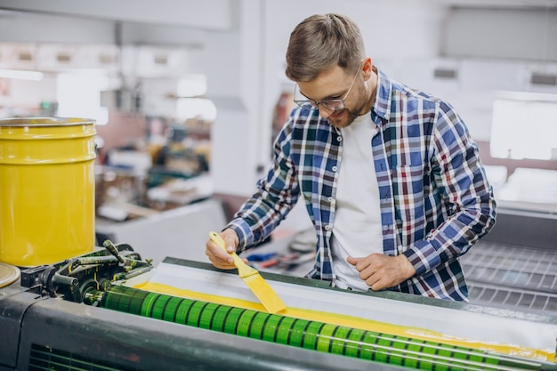 Mann, der im Druckhaus mit Papier und Farben arbeitet