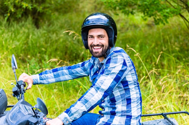 Foto mann, der im gelände mit quad oder atv fährt