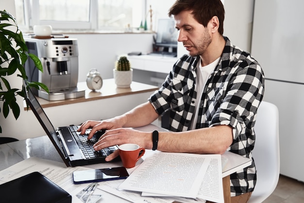 Mann, der im Home-Office mit Laptop-Online-Geschäftskonzept Fernarbeit arbeitet