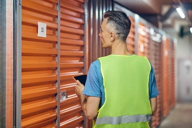 Mann, der im Lagerwächter arbeitet, der mit dem Rücken steht