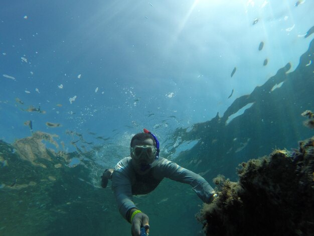 Foto mann, der im meer schwimmt