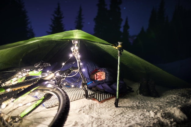 Mann, der im Winter im Zelt schläft
