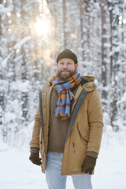 Mann, der im Winterwald geht