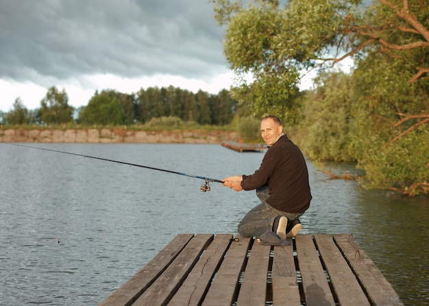 Mann, der in einem Teich an einem sonnigen Tag fischt