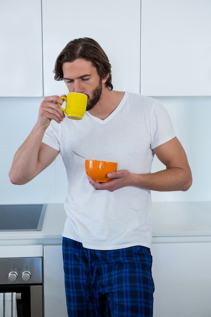 Mann, der Kaffee beim Frühstück in der Küche trinkt