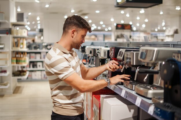 Mann, der Kaffeemaschine im Einkaufszentrum wählt