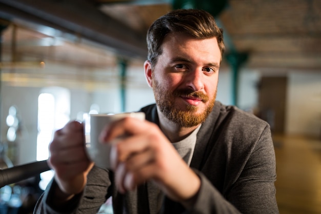 Mann, der Kaffeetasse hält