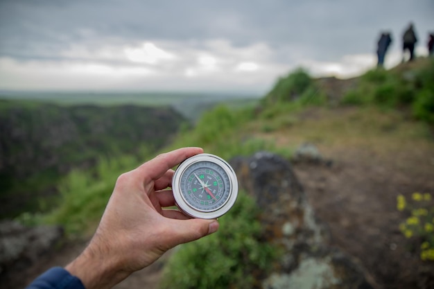 Mann, der Kompass in der Natur hält