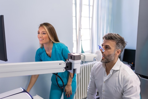 Mann, der Lungenfunktionstest und Spirometrie mit Spirometer in der medizinischen Klinik durchführt Spirometrie der Lunge