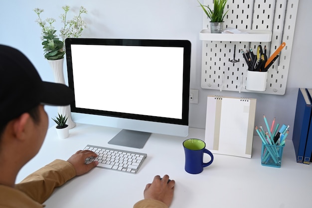 Mann, der mit Computer im modernen Büro arbeitet