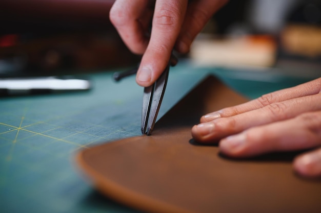 Mann, der mit Leder arbeitet, macht professionell eine Brieftasche