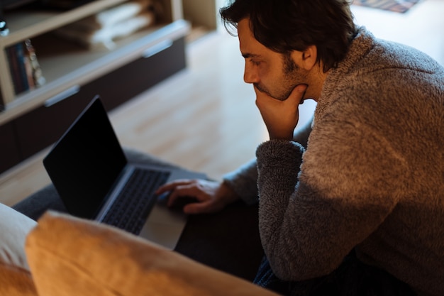 Mann, der mit seinem Laptop arbeitet