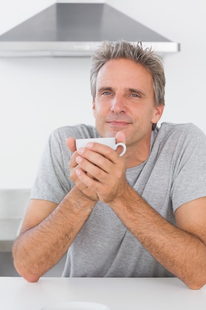 Mann, der morgens Kaffee in der Küche trinkt