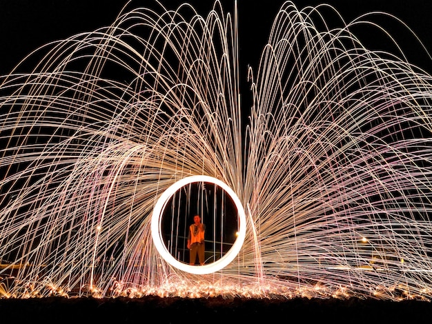 Foto mann, der nachts bei der drahtwolle steht