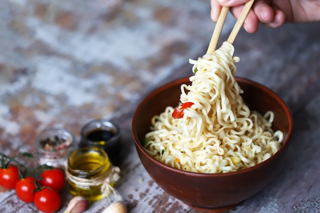 Mann, der Nudeln mit Stäbchen isst. Chinesische Nudeln.