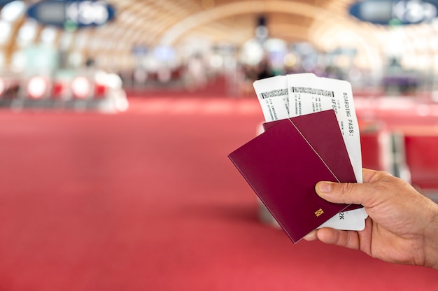 Mann, der Pässe und Bordpass am Flughafen hält. Foto in hoher Qualität