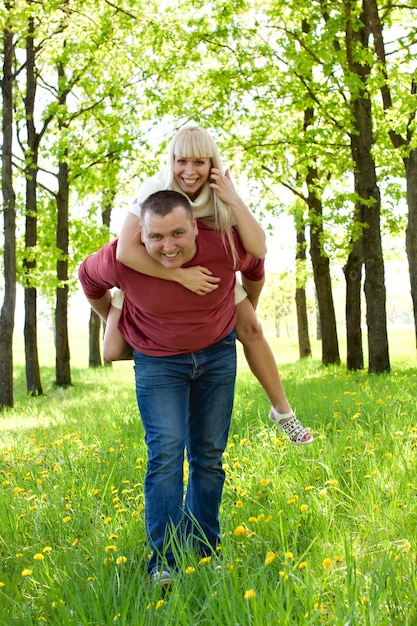 Foto mann, der piggyback der frau fahrt gibt